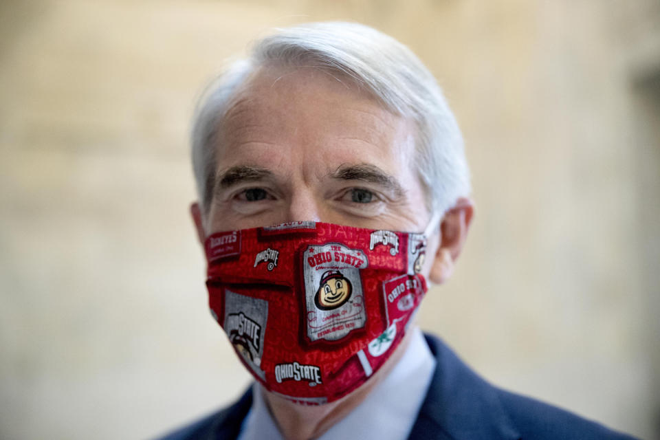 FILE - In this file photo from May 20, 2020, Sen. Rob Portman, R-Ohio, wears an Ohio State University mask as the Senate Homeland Security and Governmental Affairs committee meets on Capitol Hill in Washington. Sometimes at odds, America’s two largest generations have something to agree on: the coronavirus pandemic has smacked many at a pivotal time in their lives. For baby boomers, named for the post-World War II surge of births, that means those who retired or are nearing retirement age are seeing their retirement accounts appearing unreliable while their health is at high risk. Millennials, who became young adults in this century, are getting socked again as they were still recovering from the Great Recession. (AP Photo/Andrew Harnik)