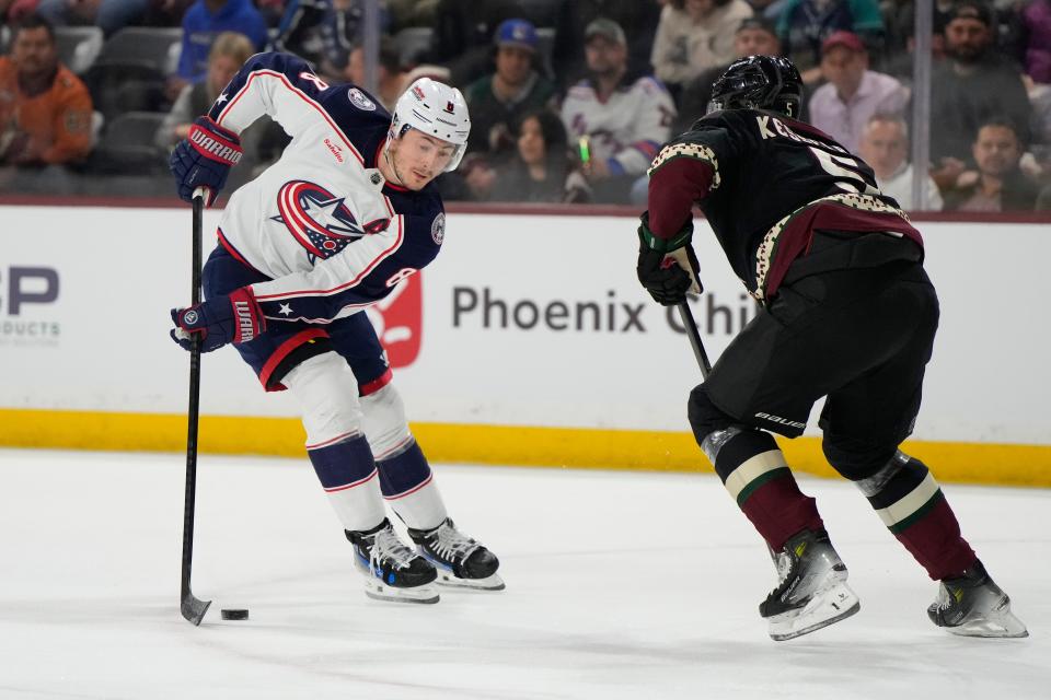 Mar 26, 2024; Tempe, Arizona, USA; Columbus Blue Jackets defenseman Zach Werenski (8) carries the puck in front of Arizona Coyotes defenseman Michael Kesselring (5) in the first period at Mullett Arena. Mandatory Credit: Rick Scuteri-USA TODAY Sports