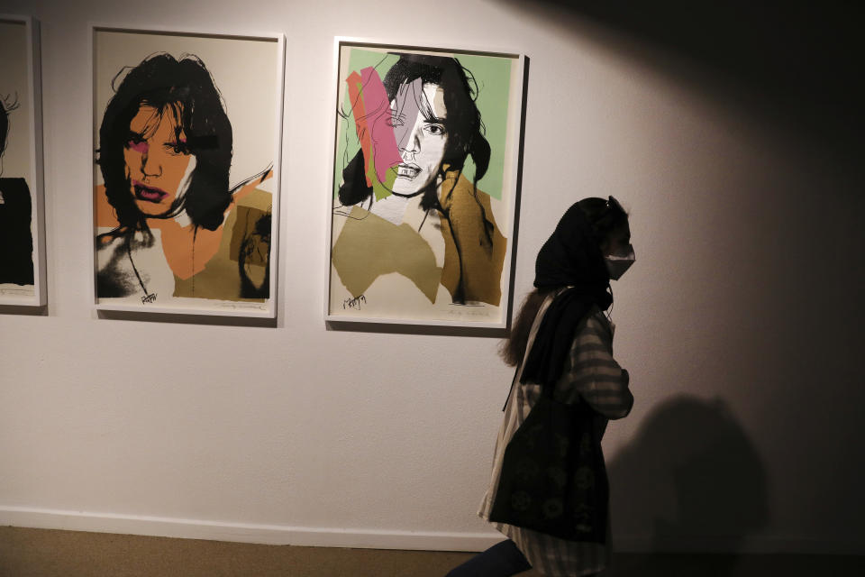 A visitor walks past Mick Jagger portrait series by American artist Andy Warhol at Tehran Museum of Contemporary Art in Tehran, Iran on Oct. 19, 2021. Iranians are flocking to Tehran's contemporary art museum to marvel at American pop artist Andy Warhol’s iconic work. (AP Photo/Vahid Salemi)