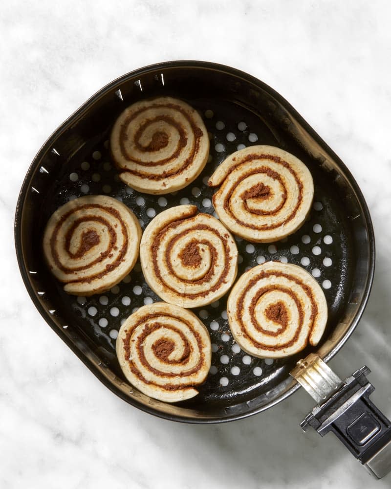 Overhead shot of unbaked cinnamon rolls in an air fryer.