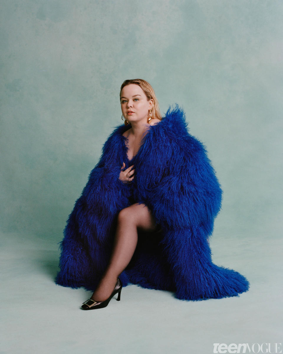 Nicola Coughlan wears a [The Attico coat](https://www.theattico.com/en/), [Roger Vivier shoes](https://www.rogervivier.com/us-en/home/), and Alexis Bittar earrings.