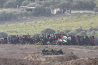 Israeli soldiers take position in front of Palestinian protesters as they gather at the Israel Gaza border, Friday, Nov. 16, 2018. (AP Photo/Tsafrir Abayov)