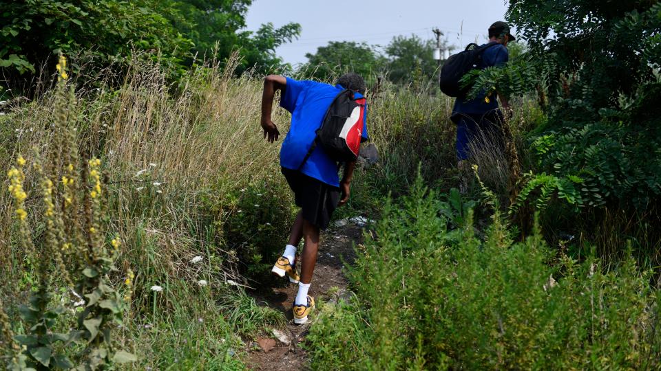 Two homeless men make their way into a homeless encampment in Camden on July 18, 2023.  