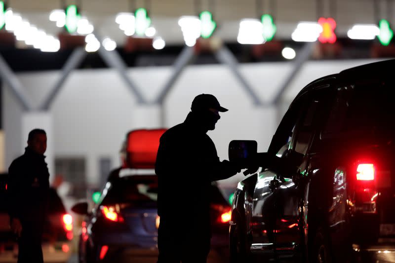 Mexican authorities inspect cars with migrants at the international border bridge between U.S. and Mexico, during the 12th Caravan of Migrants in this picture taken from Nuevo Laredo