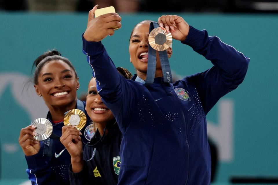 Bronze medalist Jordan Chiles takes a photo with gold medalist Rebeca Andrade and silver medalist Simone Biles. Chiles had to return her bronze medal following the decision of an independent governing body (REUTERS)