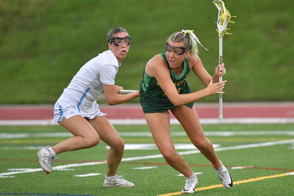 Cardinal Gibbons’ Izzi Hammond (16) looks to move against Charlotte Catholic’s Madison Baumgratz (7) during the first half. Cardinal Gibbons and Charlotte Catholic met in the NCHSAA 4A Girls Lacrosse Final at Durham County Stadium on May 17, 2024.