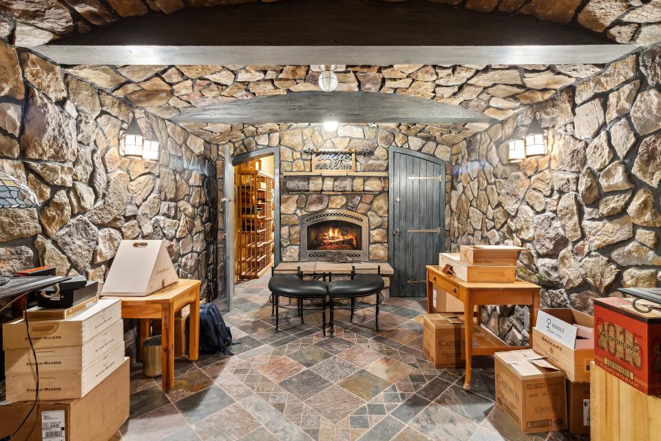 A wine cellar includes an attached tasting room with its own fireplace.