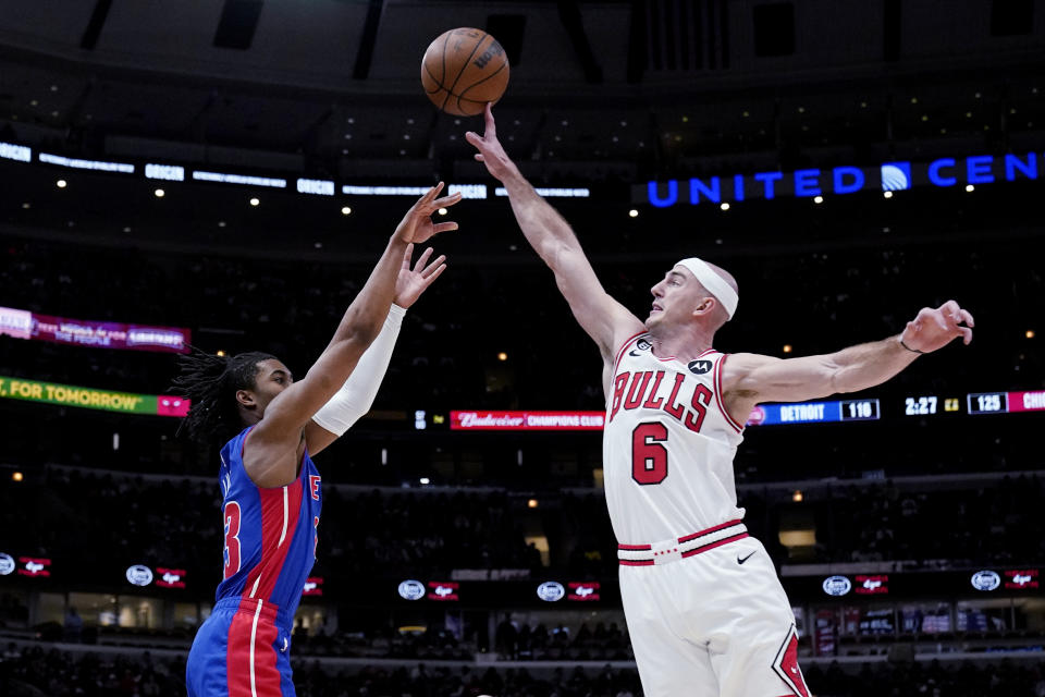 Chicago Bulls guard Alex Caruso, right, blocks a shot by Detroit Pistons guard Jaden Ivey during the second half of an NBA basketball game in Chicago, Friday, Dec. 30, 2022. The Bulls won 132-118. (AP Photo/Nam Y. Huh)