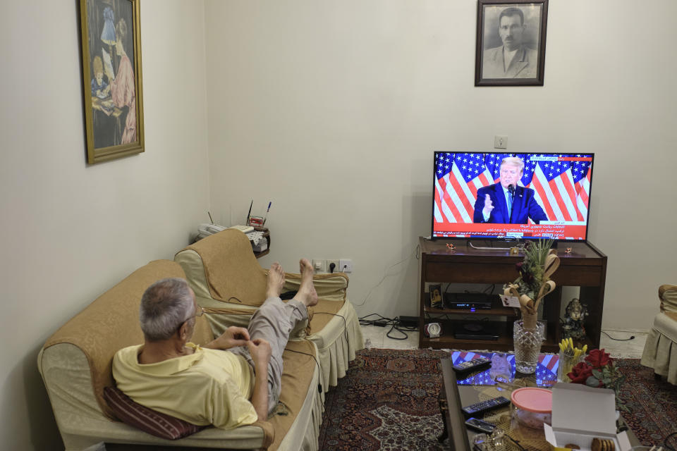 An Iranian man watches television as the US President Donald Trump addresses a crowd.