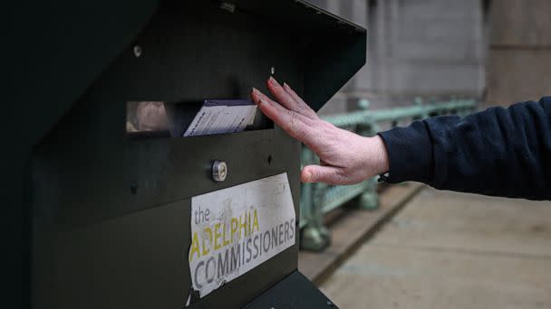 PHOTO: A voter casts their ballot at a drop box is displayed outside Philadelphia city hall on Oct. 24, 2022. (Ed Jones/AFP via Getty Images)