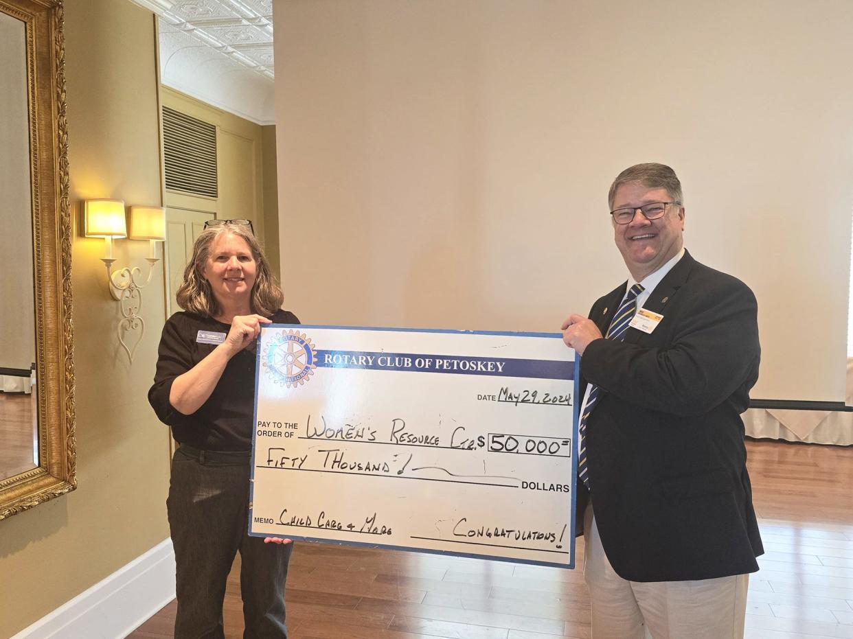 Gail Kloss, executive director of the Women's Resource Center of Northern Michigan, receives a $50,000 donation from the Rotary Club of Petoskey, presented by past president Reg Smith, to support the expansion of the Children's Learning Center.