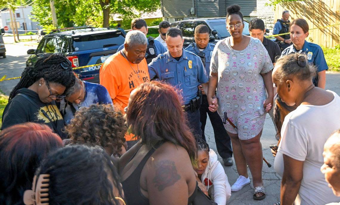 Kansas City Police Sgt. Jake Becchina and Chief Stacey Graves gathered with people including Pat Clarke and Cherron Barney in the street to pray after three people died and five were injured following a shooting early Sunday, June 25, 2023, near 57th Street and Prospect Avenue in Kansas City.