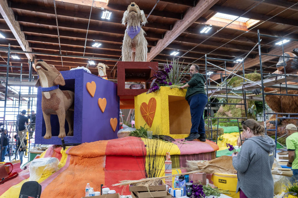 People work on the Pasadena Humane Hill's Pet Nutrition's "Feed The Love" Rose Parade float