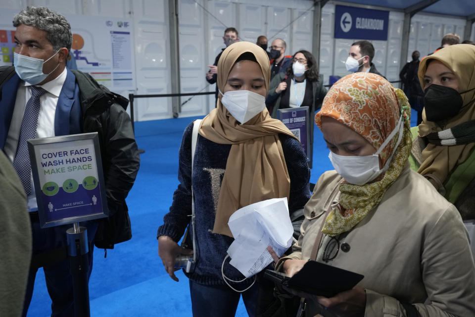 FILE - In this Oct. 29, 2021, file photo, attendees wait for registration to enter the venue where the U.N. climate conference will be held in Glasgow, Scotland. Despite the concerns about the coronavirus from some of the delegates from around the world, the British government decided to hold an in-person conference, arguing that world leaders must act now to prevent catastrophic global warming — and that they will be more effective if they can talk face-to-face. (AP Photo/Matt Dunham, File)