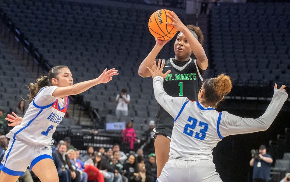 St. Mary's Kori Rogers, center, shoots over Folsom's Ella Uriarte, left, and Jada Tupou during the Sac-Joaquin Section girls basketball championship game at Golden One Center in Sacramento on Feb. 21. 2024. St. Mary's won 57-51.