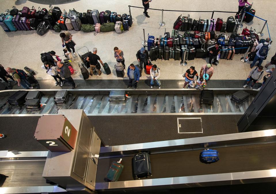 Travelers wait for their luggage at Austin-Bergstrom on June 30, the busy kickoff to the long July Fourth holiday weekend.