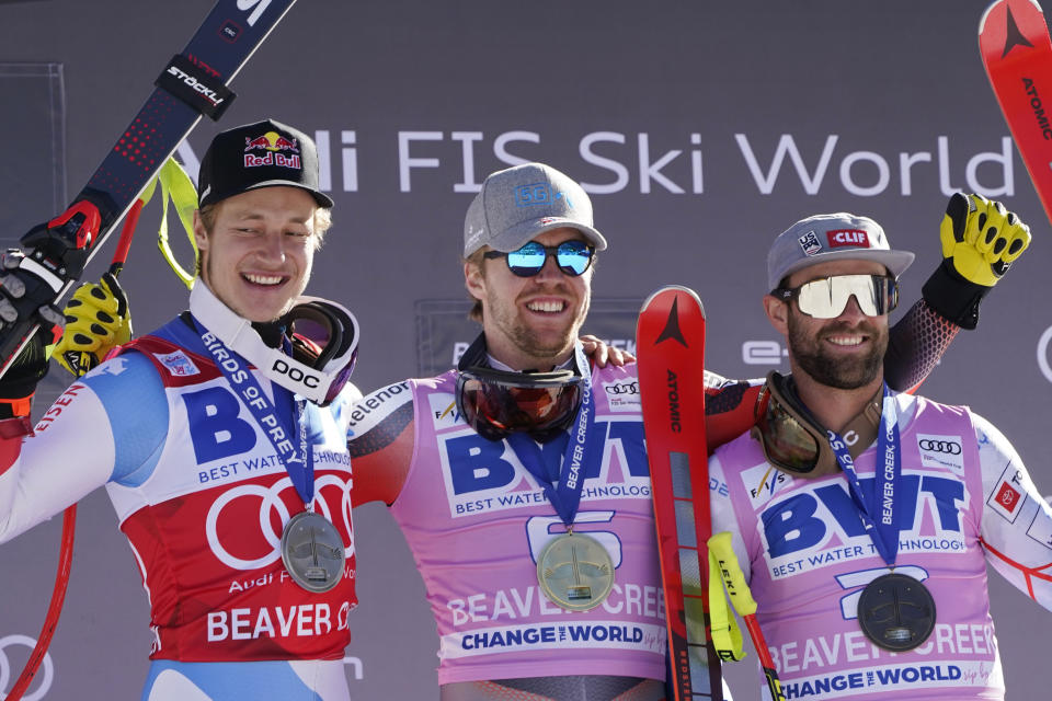 Norway's Aleksander Aamodt Kilde, center, celebrates a first place finish while posing beside second-place finisher Switzerland's Marco Odermatt, left, and third-place finisher United States' Travis Ganong after a men's World Cup super-G skiing race Friday, Dec. 3, 2021, in Beaver Creek, Colo. (AP Photo/Gregory Bull)