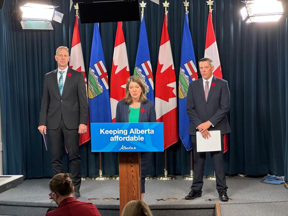Alberta Premier Danielle Smith, centre, announces short- and long-term plans to reform auto insurance in Alberta at the legislature on Nov. 1, 2023. She is flanked on the left by Affordability and Utilities Minister Nathan Neudorf and Finance Minister Nate Horner, right.