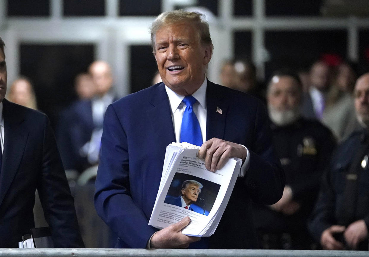 Former President Donald Trump holds news clippings as he leaves court for the day on April 18, 2024. (Timothy A. Clary / Pool via Getty Images)