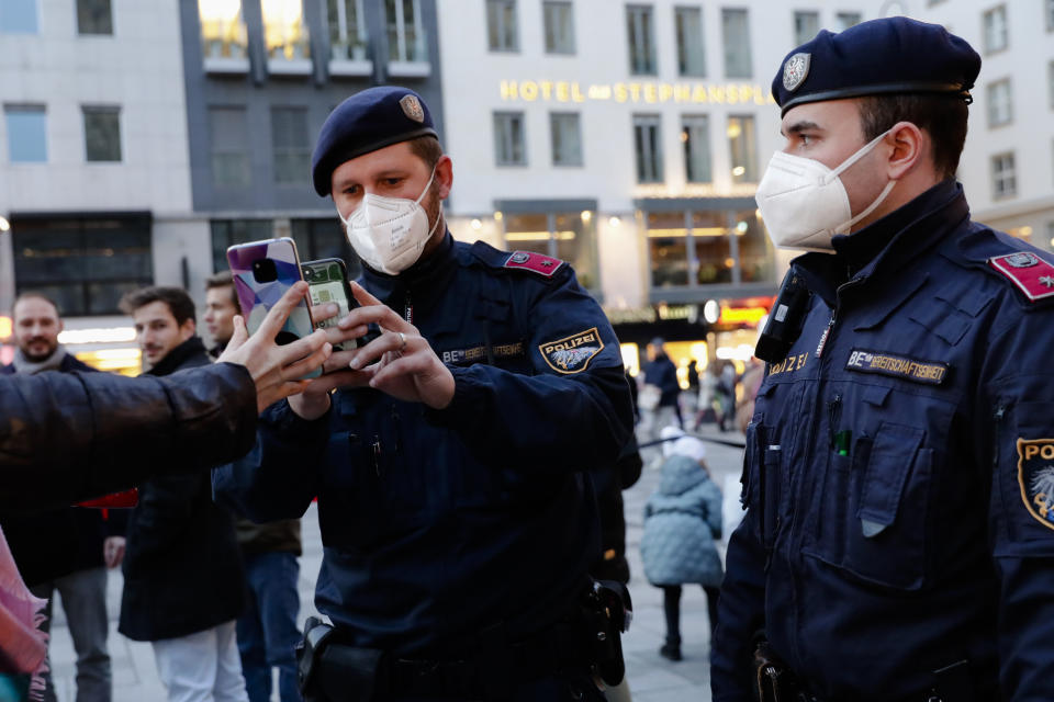 FILE - Police officers check the vaccination status of visitors during a patrol on a Christmas market in Vienna, Austria, Friday, Nov. 19, 2021. This was supposed to be the Christmas in Europe where family and friends could once again embrace holiday festivities and one another. Instead, the continent is the global epicenter of the COVID-19 pandemic as cases soar to record levels in many countries. With infections spiking again despite nearly two years of restrictions, the health crisis increasingly is pitting citizen against citizen — the vaccinated against the unvaccinated.(AP Photo/Lisa Leutner, File)