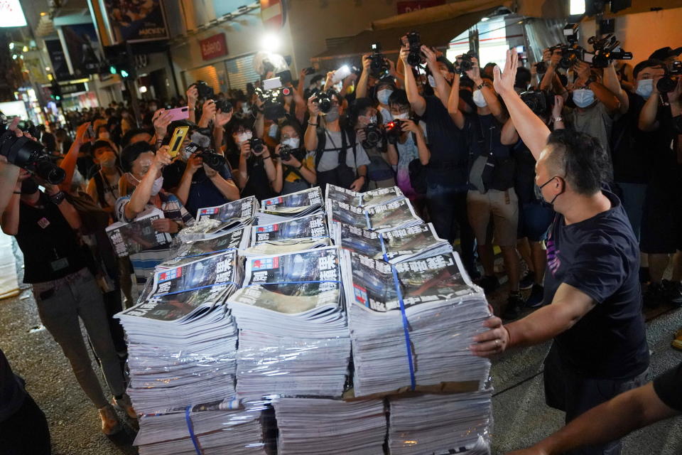 A man gestures as he brings copies of the final edition of Apple Daily, published by Next Digital, to a news stand in Hong Kong, China June 24, 2021. REUTERS/Lam Yik