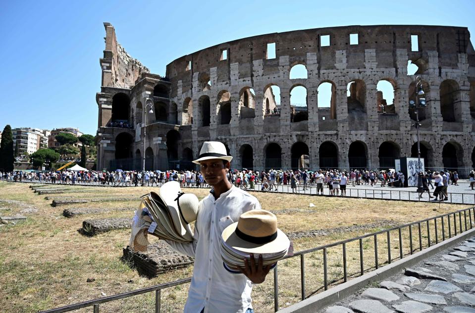 A street vendor sells his hats to tourists in front of the Colosseum in Rome on July 26, 2019 during a heatwave that smashed records across Europe. - The heatwave, which was expected to ease up on July 26, 2019 as rain and thunderstorms move in, again focused public attention on the problems caused by climate change. (Photo by Vincenzo PINTO / AFP)        (Photo credit should read VINCENZO PINTO/AFP/Getty Images)