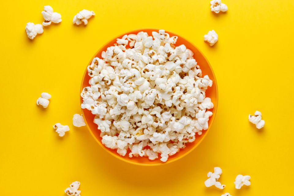 popcorn in orange bowl on yellow background