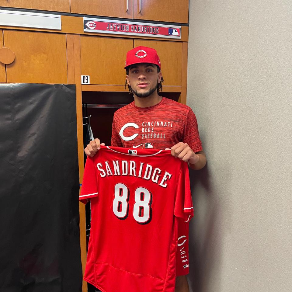 Hagerstown's Jayvien Sandridge shows off his new wardrobe, including his jersey, after signing a free-agent contract with the Cincinnati Reds.