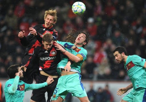 Leverkusen's striker Stefan Kiessling (L), midfielder Lars Bender and Barcelona's defender Carles Puyol (C) vie for the ball during the UEFA Champions League round of sixteen first leg match Bayer Leverkusen vs FC Barcelona at BayArena in Leverkusen, western Germany. Barcelona took a giant step towards the Champions League's quarter-finals with a 3-1 win at Bayer Leverkusen