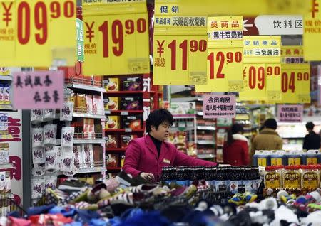 A sales assistant arrange products at a supermarket in Zouping, Shandong province, March 10, 2015. REUTERS/China Daily/Files