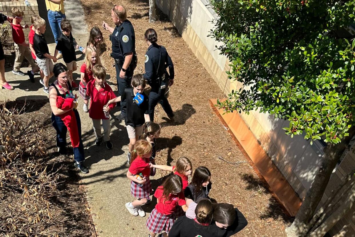 Children in school uniforms wait in line.