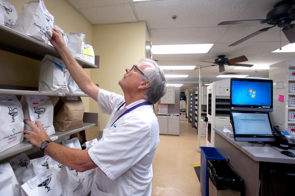 Pharmacist Bill Harris pulls a patient's prescriptions down from the shelf at the Portland Family Health Center.July 26, 2018