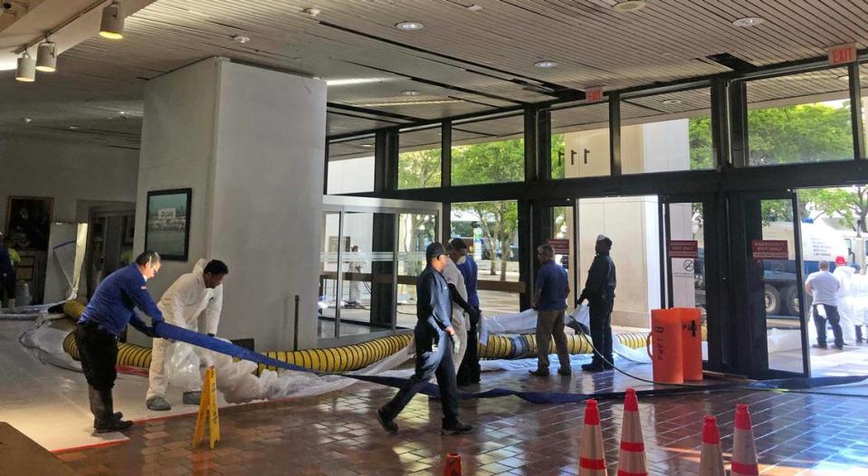 Workers clean up the Stephen P. Clark Government Center after a sewer pipe burst Tuesday.