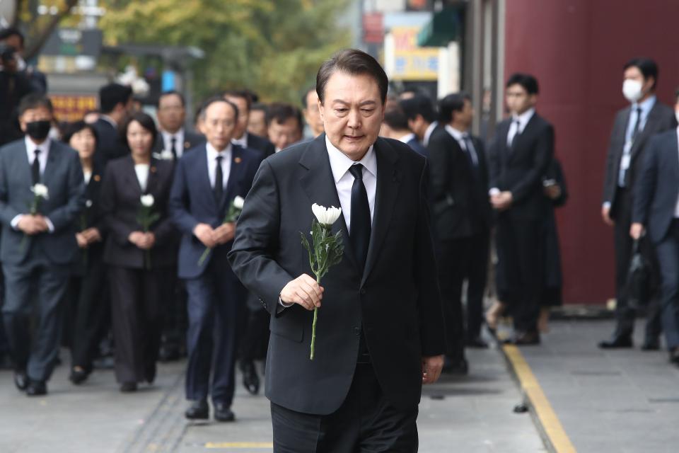 South Korean president Yoon Suk-yeol holds a flower for the victims of the Halloween celebration stampede, on the street near the scene on 1 November 2022 in Seoul, South Korea (Getty Images)