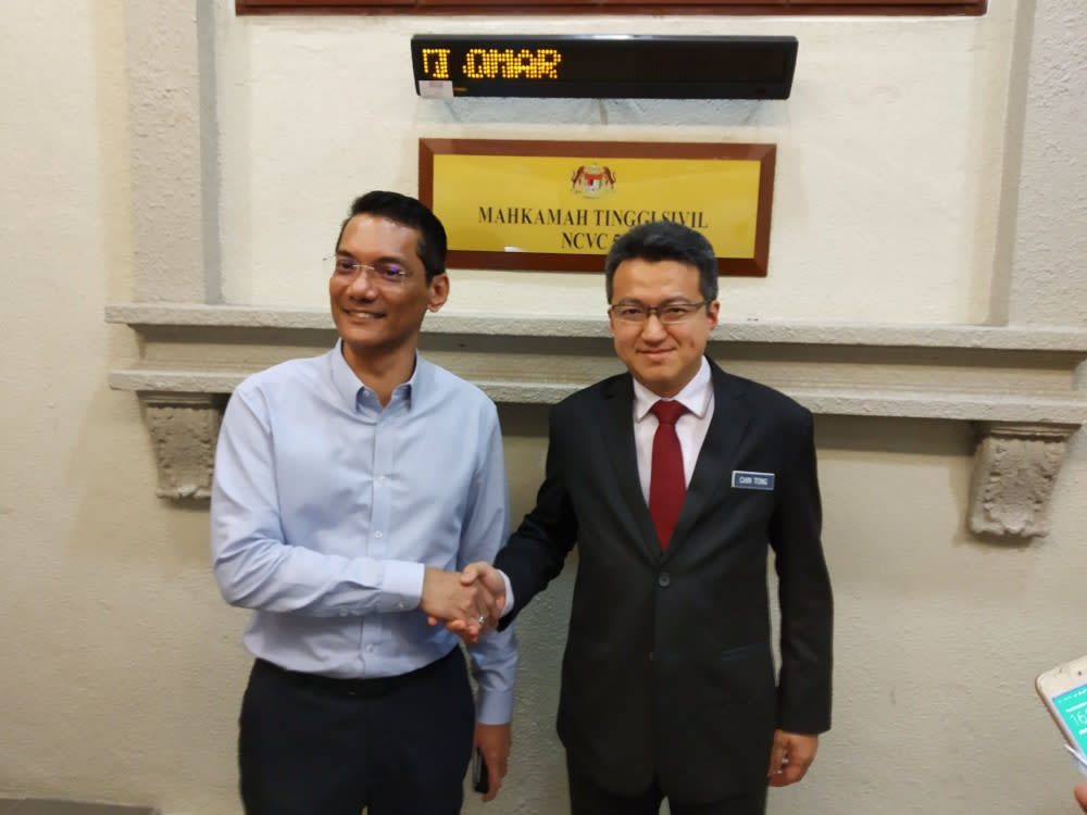 Jaringan Melayu Malaysia president Datuk Azwanddin Hamzah and Deputy Defence Minister Senator Liew Chin Tong shaking hands in the High Court building August 28, 2019. — Picture from Twitter/Liew Chin Tong