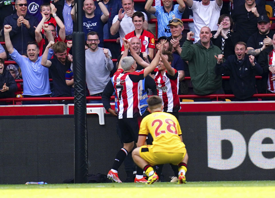 Brentford's Neal Maupay, left, and Mikkel Damsgaard celebrate after Sheffield United's Ollie Arblaster, not pictured, scores an own goal during the English Premier League soccer match between Brentford and Sheffield United at the Gtech Community Stadium in London, Saturday, April 13, 2024. (John Walton/PA via AP)