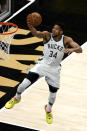 Milwaukee Bucks forward Giannis Antetokounmpo (34) goes in for a basket during the first half of the team's NBA basketball game against the Atlanta Hawks on Thursday, April 15, 2021, in Atlanta. (AP Photo/John Bazemore)