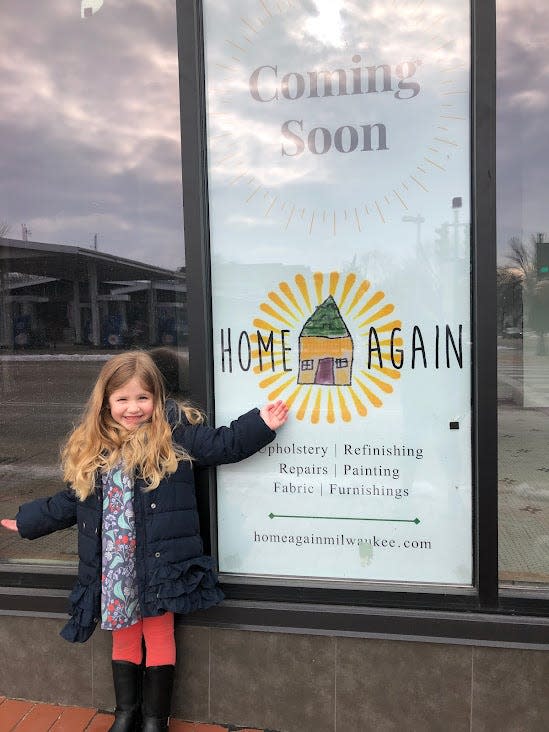 Owner Kristina Bruggeman's daughter stands in front of the Home Again, a re-upholstering or furniture restoration business in Shorewood.