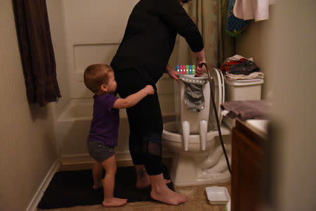 Asa hugs Lauren Hoffmann as she washes cloth diapers in San Antonio, Texas, U.S., February 7, 2019. REUTERS/Callaghan O'Hare
