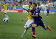 Colombia's Santiago Arias (L) fights for the ball with Japan's Yuto Nagatomo during their 2014 World Cup Group C soccer match at the Pantanal arena in Cuiaba June 24, 2014. REUTERS/Eric Gaillard (BRAZIL - Tags: SOCCER SPORT WORLD CUP)