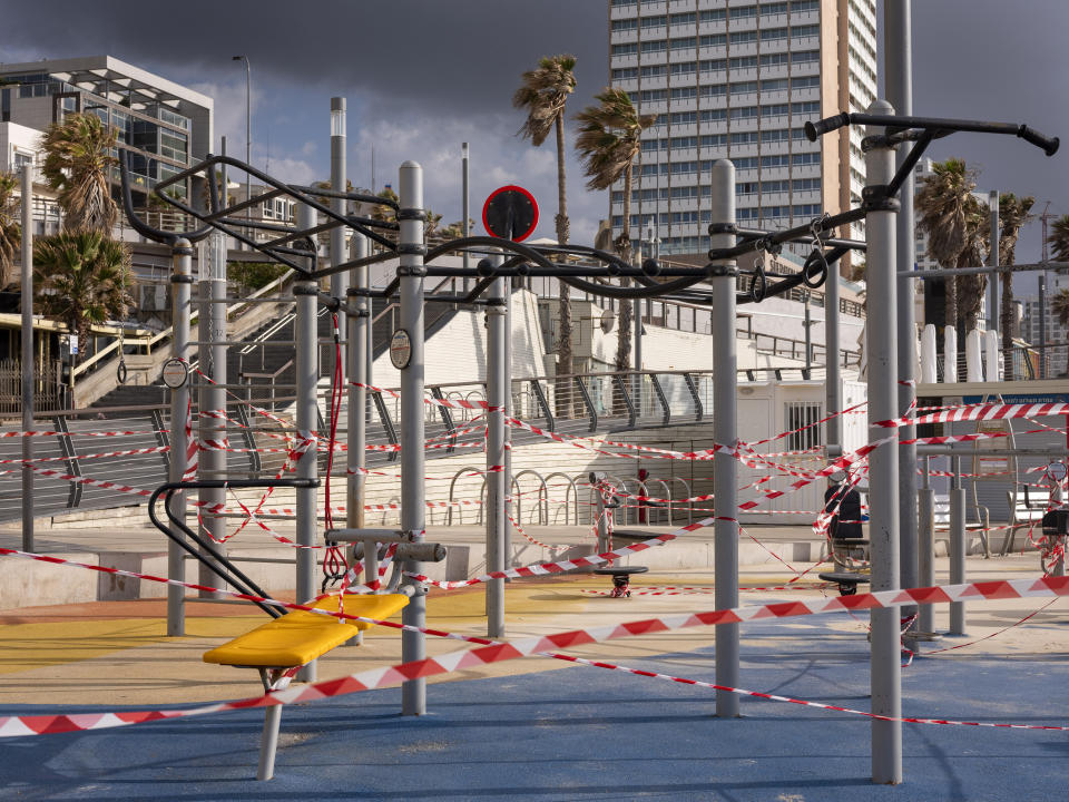 This Thursday, March 19, 2020 photo shows a free gym at Tel Aviv's beachfront wrapped in tape to prevent public access. Israel has reported a steady increase in confirmed cases despite imposing strict travel bans and quarantine measures more than two weeks ago. Authorities recently ordered the closure of all non-essential businesses and encouraged people to work from home. (AP Photo/Oded Balilty)