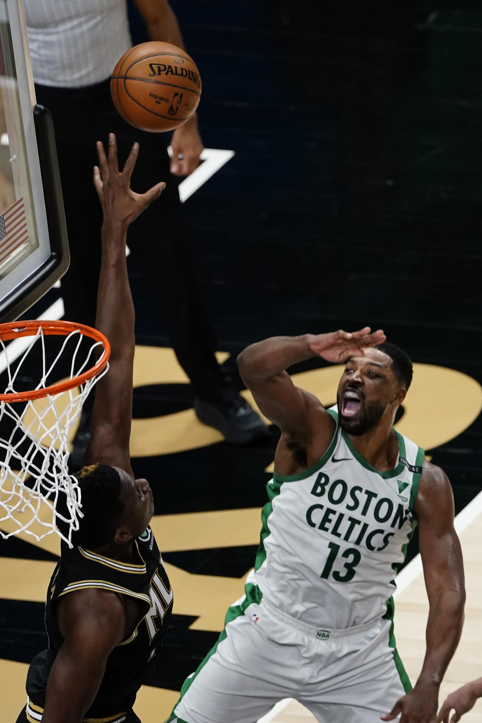 Boston Celtics forward Tristan Thompson (13) reacts as he shots against Atlanta Hawks center Clint Capela (15) in the first half of an NBA basketball game Wednesday, Feb. 24, 2021, in Atlanta. (AP Photo/John Bazemore)