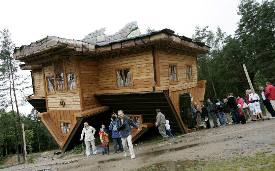 People wait in line to visit an upside-down house built at the Centre of Education and Promotion of the Region in the village of Szymbark