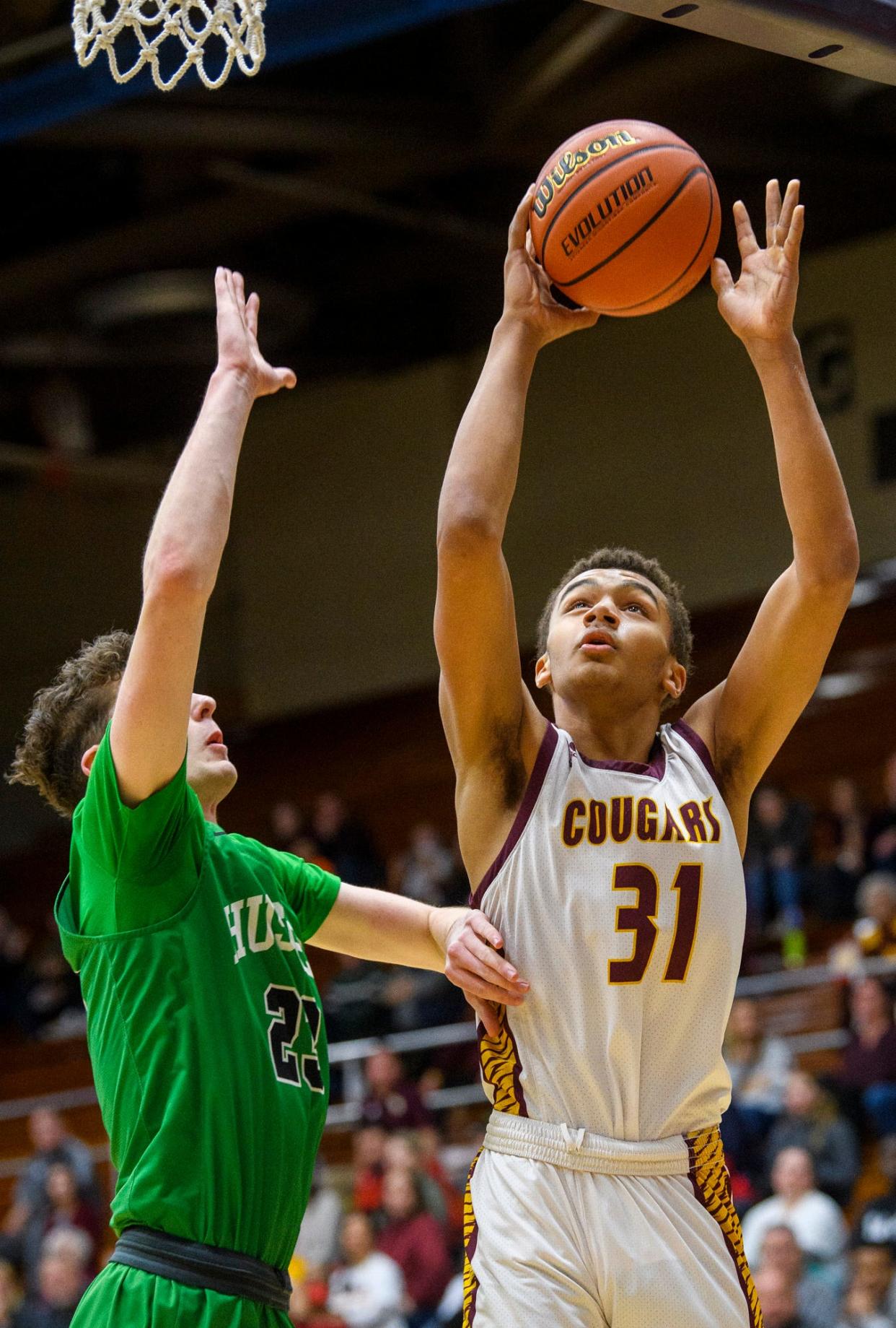 Bloomington North's Bril Kante (31) shoots in front of Evansville North's Mason Wicks (23) during the first game of the IHSAA regional at Seymour High School on Saturday, March 12, 2022.