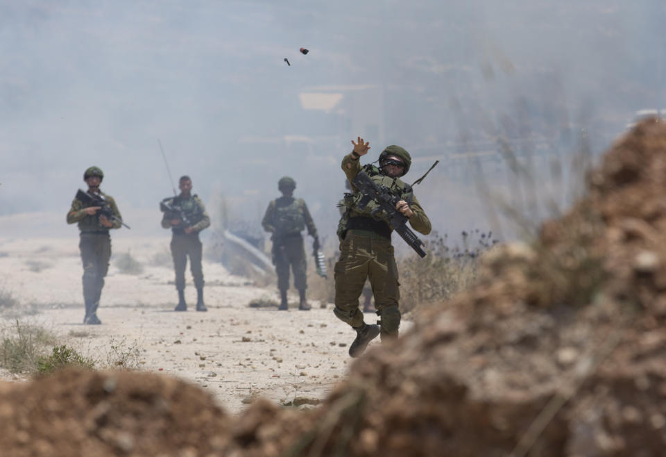 Israeli border police use teargas to disperse Palestinian protesters during a rally against the American-led Mideast peace conference, near the settlement of Beit El, at the outskirts of the West Bank city of Ramallah Tuesday, June. 25, 2019. (AP Photo/Nasser Nasser)