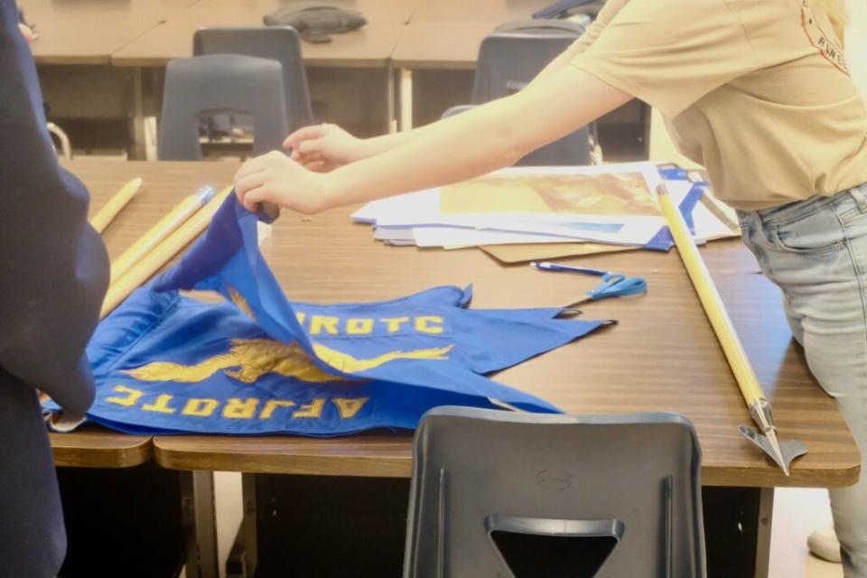An Air Force JROTC student folds a flag in a Ben Eielson Junior Senior High School classroom on April 22, 2024. (Photo by Claire Stremple/Alaska Beacon)