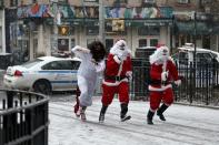 Revellers dressed as Santa Claus run in a park during the SantaCon event in New York December 14, 2013. Every year since 1997, thousands of men and women have dressed up as Santas, elves, reindeer or some other holiday confection and descended on the city's streets for a daylong bar crawl that begins with good cheer and, for many, inevitably ends in a blurry booze-soaked haze. Many come from Long Island and New Jersey, getting a head start on the festivities on the train ride into the city. REUTERS/Eduardo Munoz (UNITED STATES - Tags: SOCIETY ENTERTAINMENT)