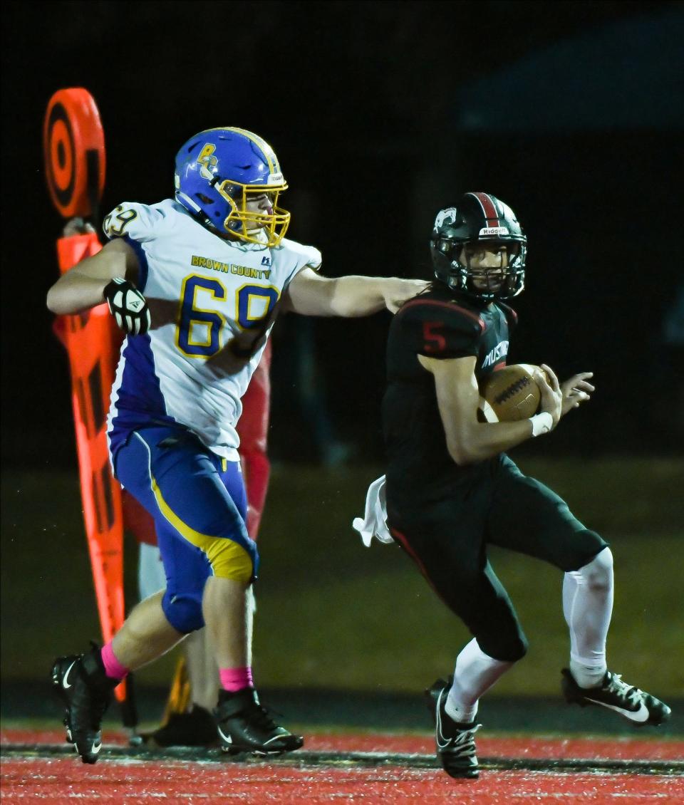 Edgewood’s Nehemiah Strunk (5) runs upfield past Brown County’s Jackson Daugherty (69) during their football game at Edgewood on Friday, Oct. 13, 2023.