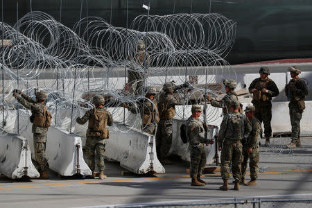 U.S. Marines help to build a concertina wire barricade at the U.S. Mexico border in preparation for the arrival of a caravan of migrants at the San Ysidro border crossing in San Diego, California, U.S., November 13, 2018. REUTERS/Mike Blake