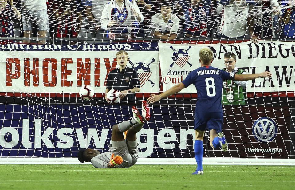 United States midfielder Djordje Mihailovic (8) scores a goal against Panama goalkeeper Eddie Roberts, left, during the first half of a men's international friendly soccer match Sunday, Jan. 27, 2019, in Phoenix. (AP Photo/Ross D. Franklin)